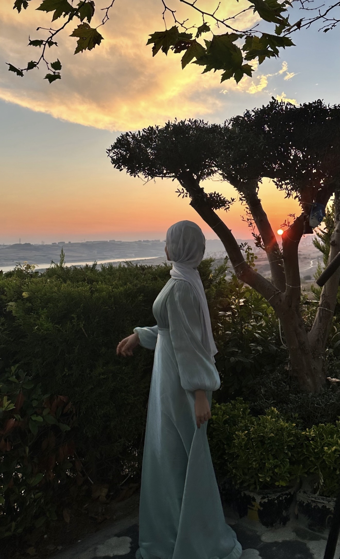 Deema beneath the trees at sunset, one portrait blending from color photography on the left into pencil drawing on the right
